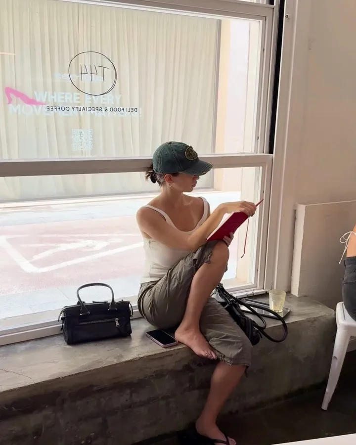 Una dona llegint al banc de la finestra